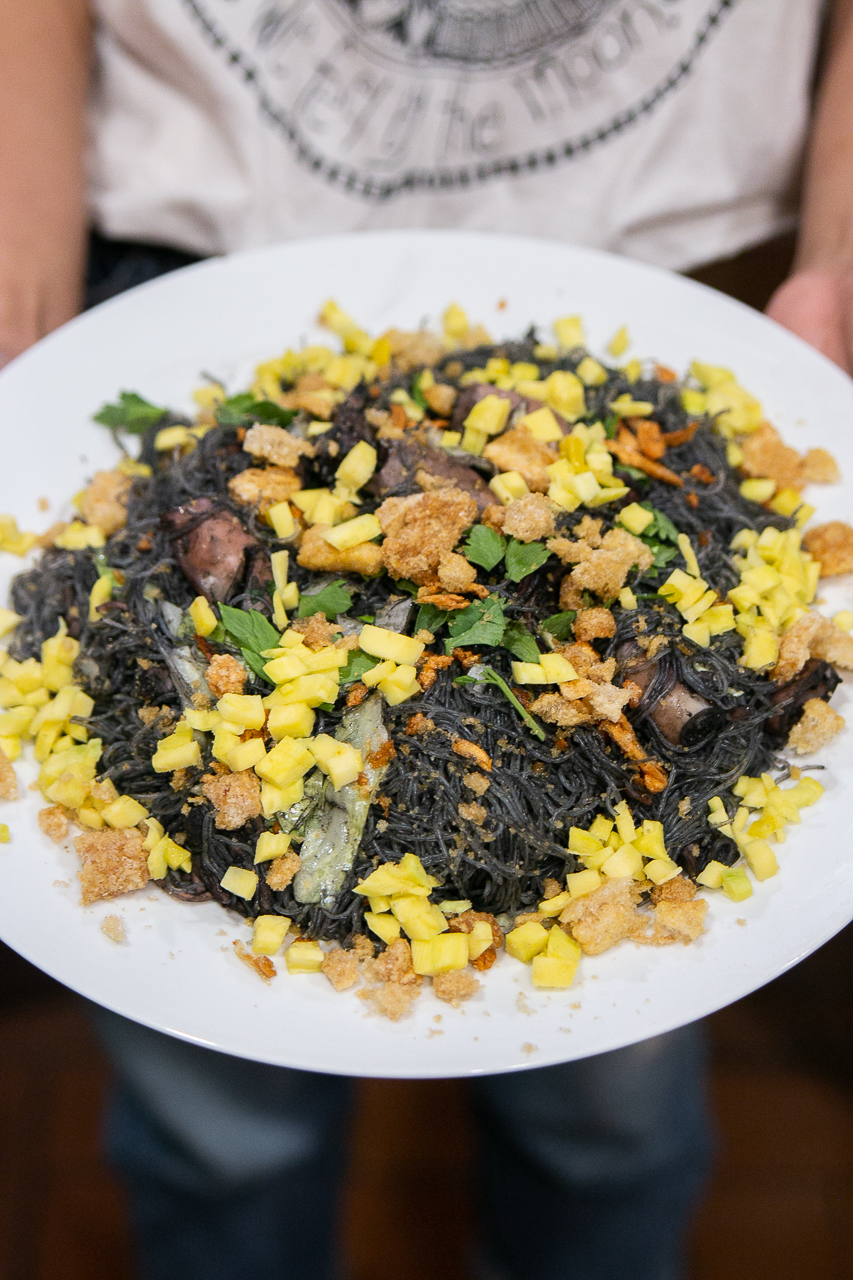 Cavite cuisine: Pansit pusit is a savory dish topped with mangoes and chicharon