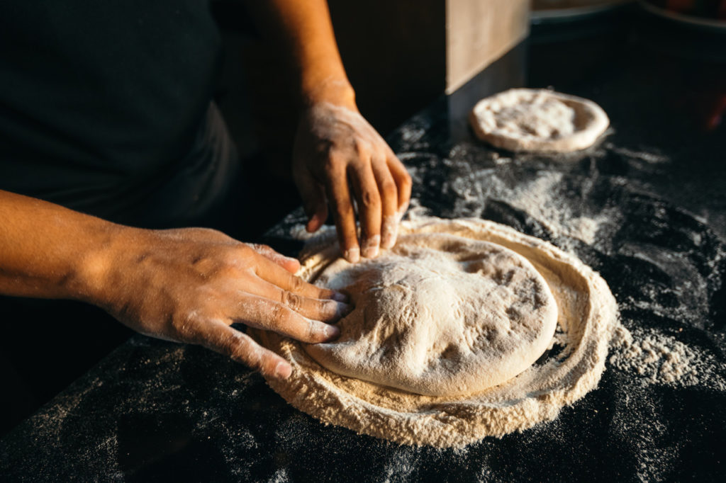 Kneading and molding fresh pizza dough inside Kermit's kitchen