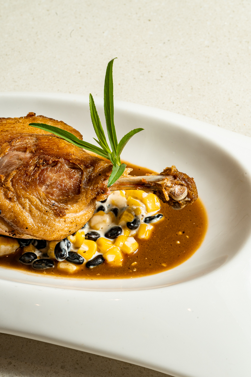 Duck leg confit with corn, black bean relish, truffle syrup