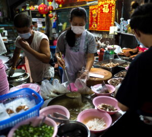 Adulwitch Tangsupmanee, 42, and Jirintat, son and daughter of Chanchai Tangsupmanee, who died at age 73 of the coronavirus disease (COVID-19) in July, during Thailand's worst wave of infections prepare meals at their late father's food stall in Bangkok's Chinatown