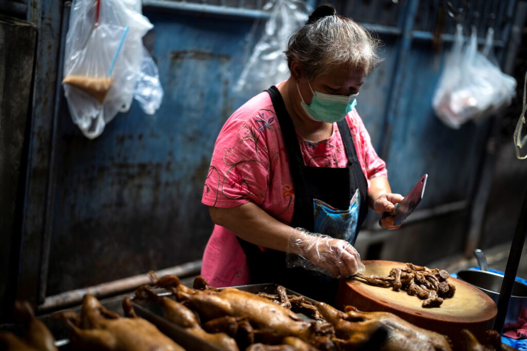 Janya Saetang chops meat at her late sister's food stall in Bangkok