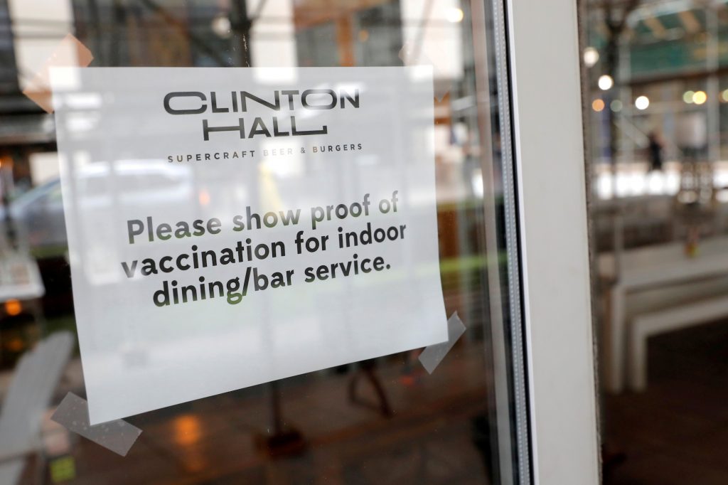Signage is seen on a window in a restaurant as the vaccination mandate commenced during the outbreak of COVID-19 in Manhattan, New York City
