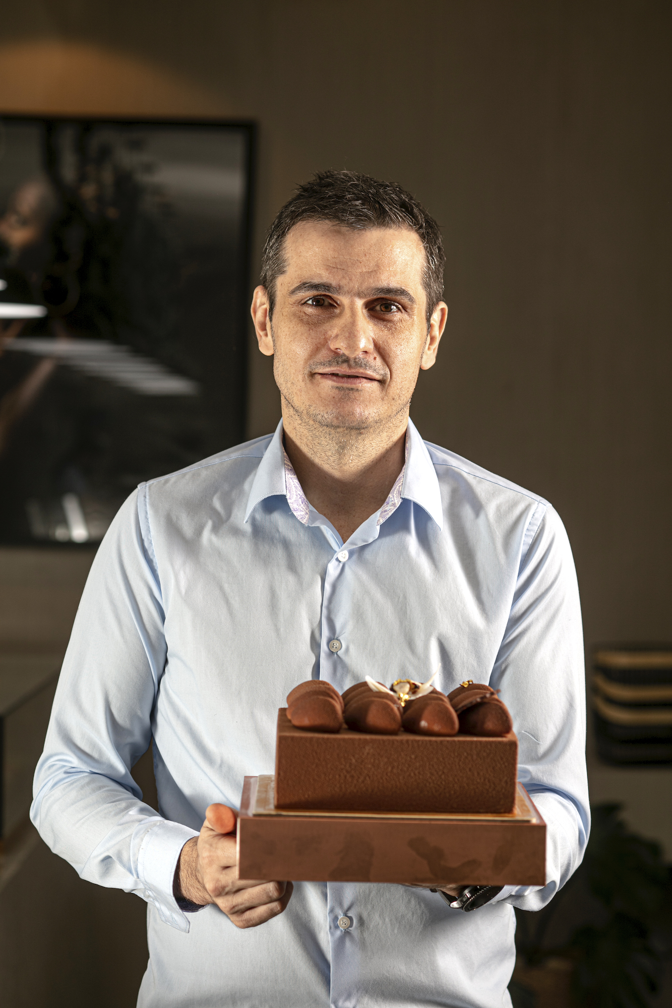 Dylan Patisserie general manager Nikola Ivanov holding one of their signature cakes: De Hazelnut Praline