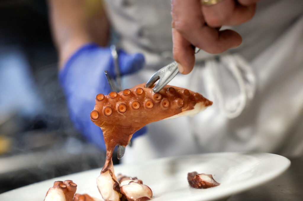 David Galvez, chef at the Casa Gallega restaurant, prepares an octopus to serve after cooking it in the traditional Galician way in Madrid, Spain