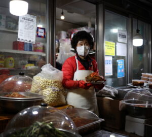 FILE PHOTO: Choi Sun-hwa poses for a photograph with traditional Korean side dish kimchi at her side dish store at a traditional market in Seoul, South Korea