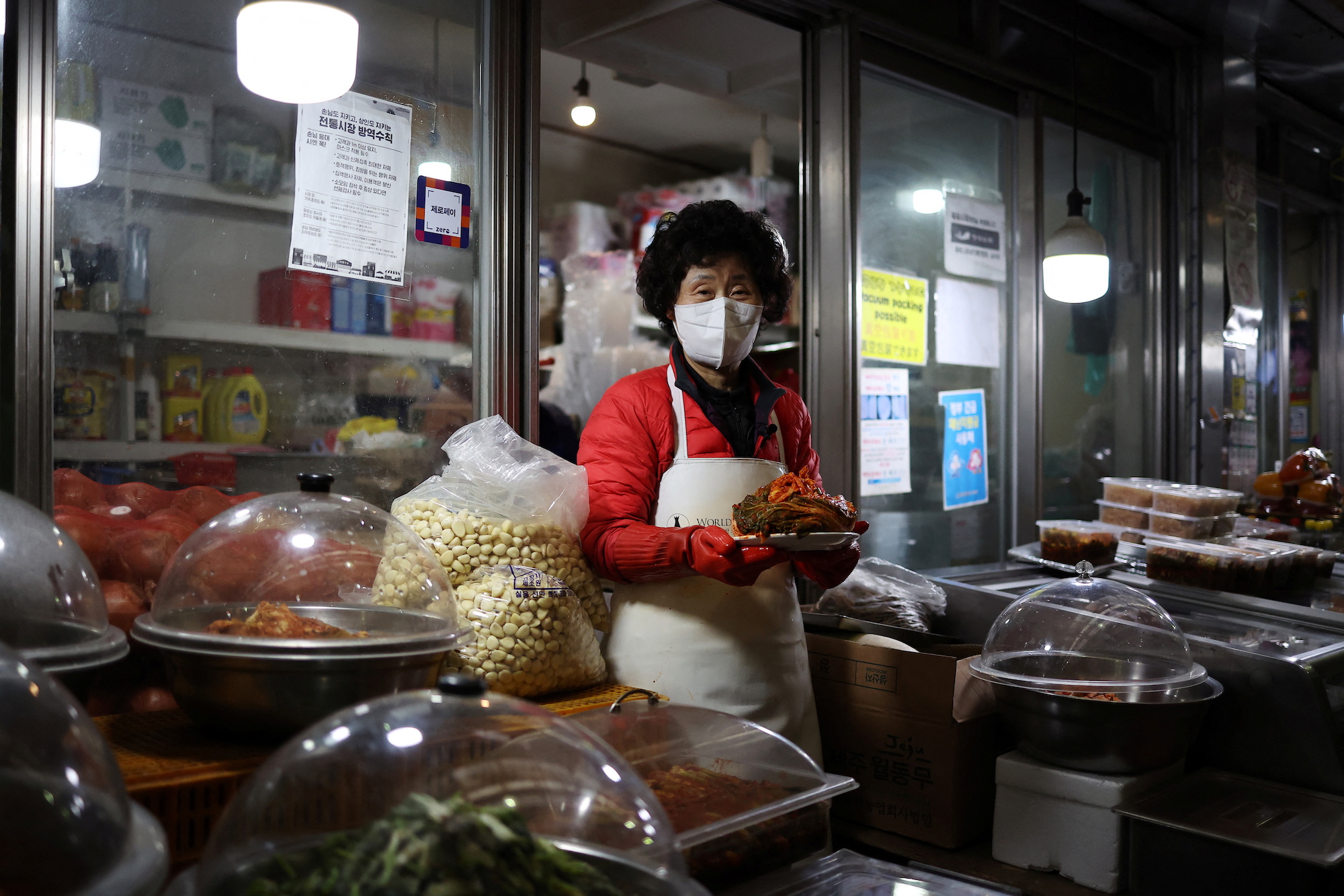 FILE PHOTO: Choi Sun-hwa poses for a photograph with traditional Korean side dish kimchi at her side dish store at a traditional market in Seoul, South Korea