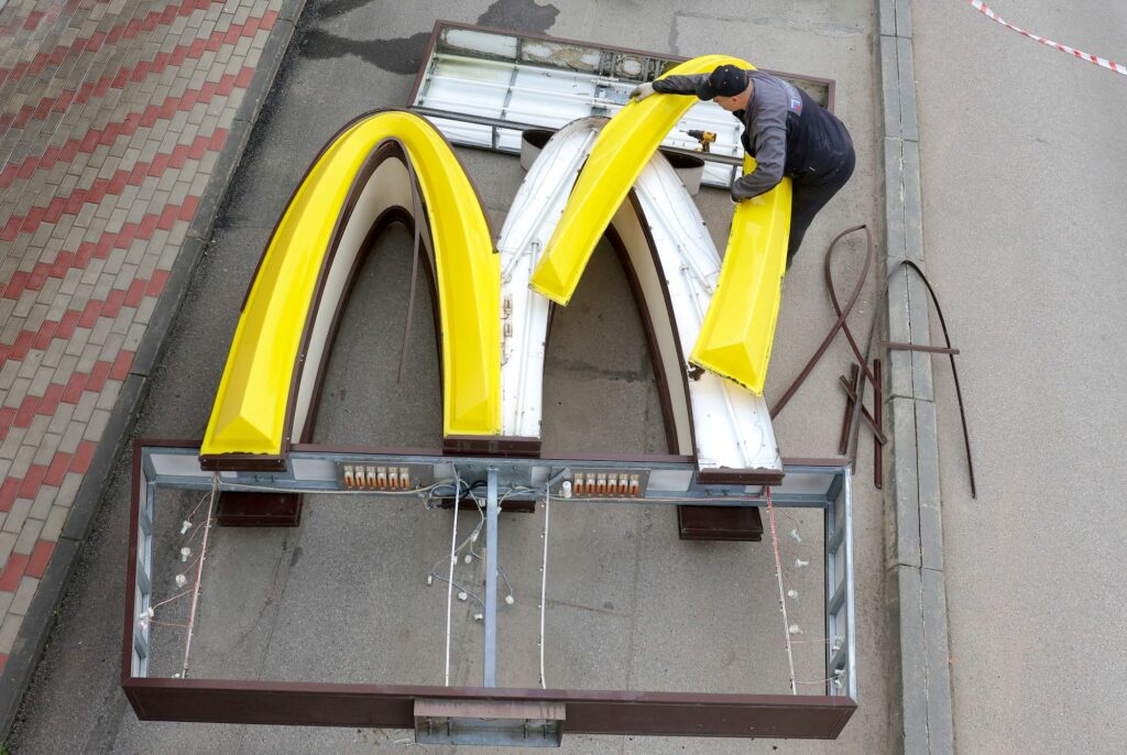 A worker dismantles the McDonald's Golden Arches while removing the logo signage from a drive-through restaurant of McDonald's in the town of Kingisepp in the Leningrad region, Russia
