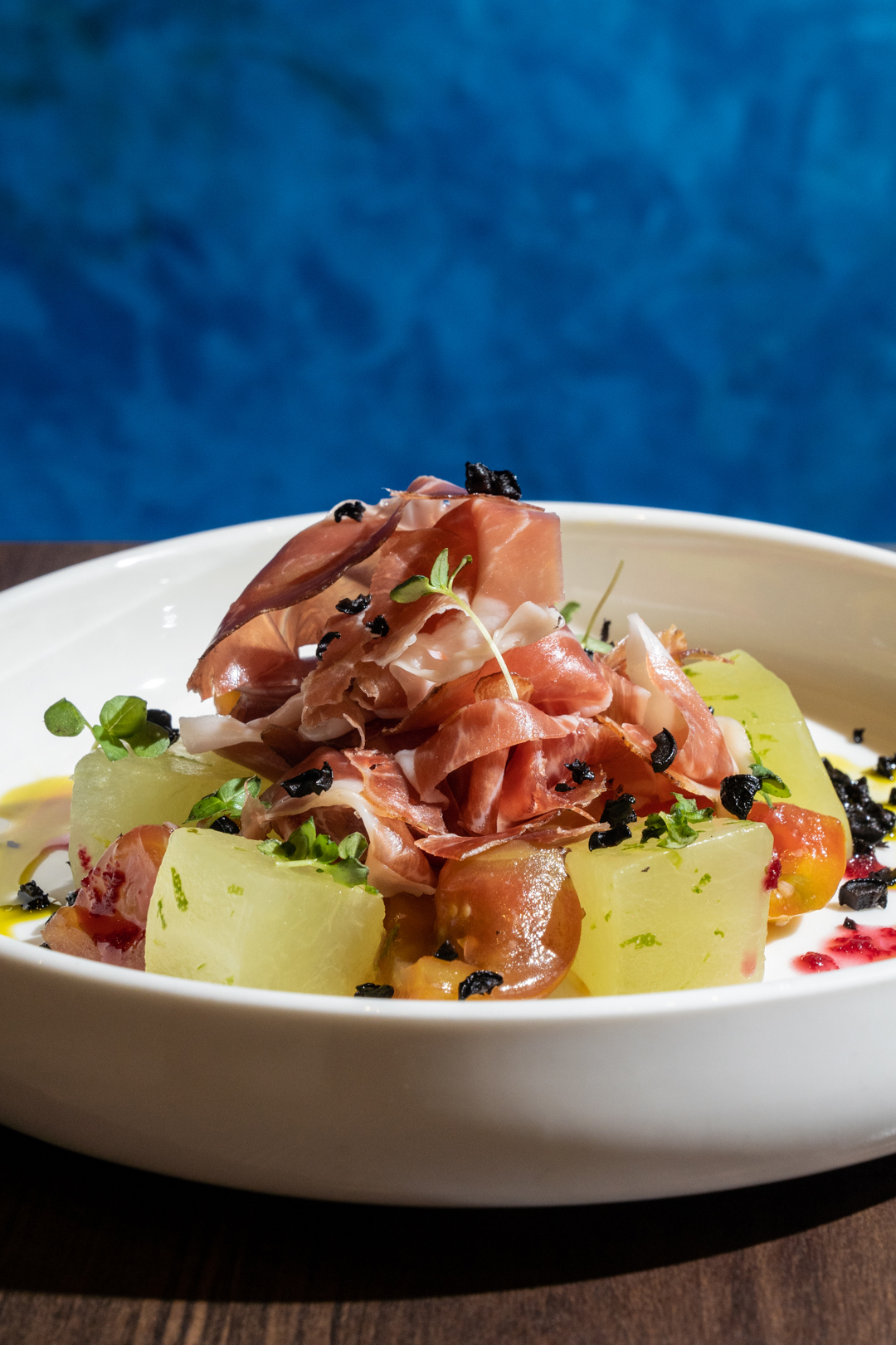 Jamón: Prosciutto di parma, lime-compressed honeydew, white balsamic marinated tomatoes, air-dried olives