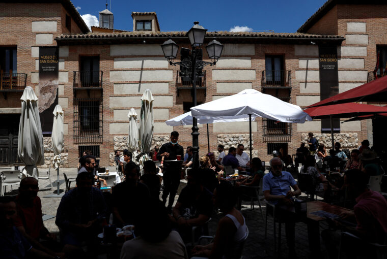 No experience, no resume, you're hired! European hotels fight for staff: A waiter works at a crowded restaurant terrace in central Madrid, Spain