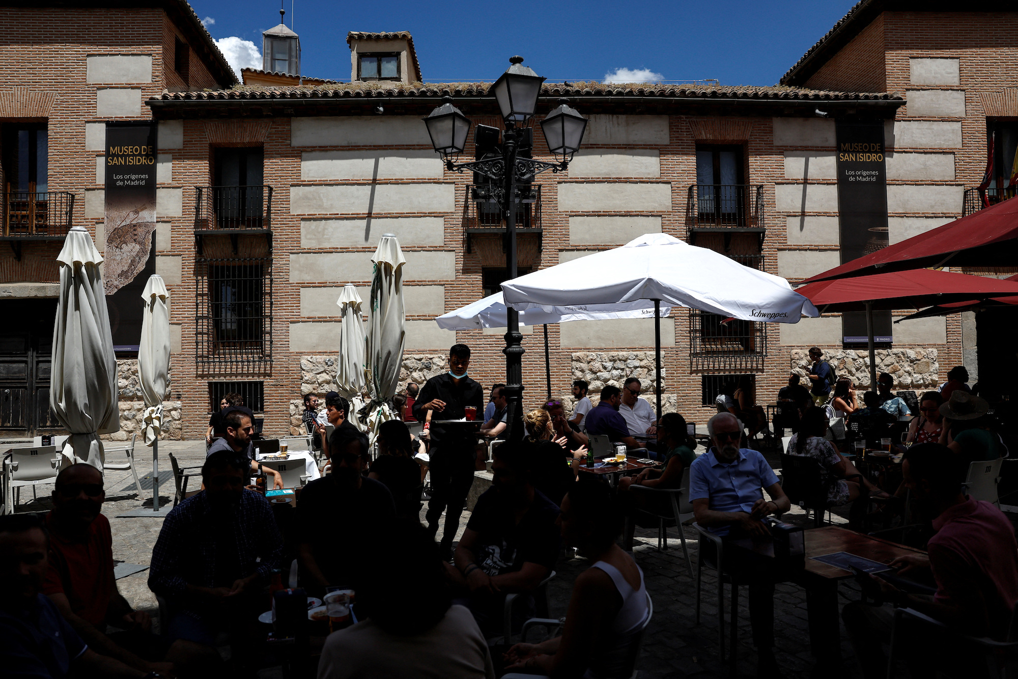No experience, no resume, you're hired! European hotels fight for staff: A waiter works at a crowded restaurant terrace in central Madrid, Spain