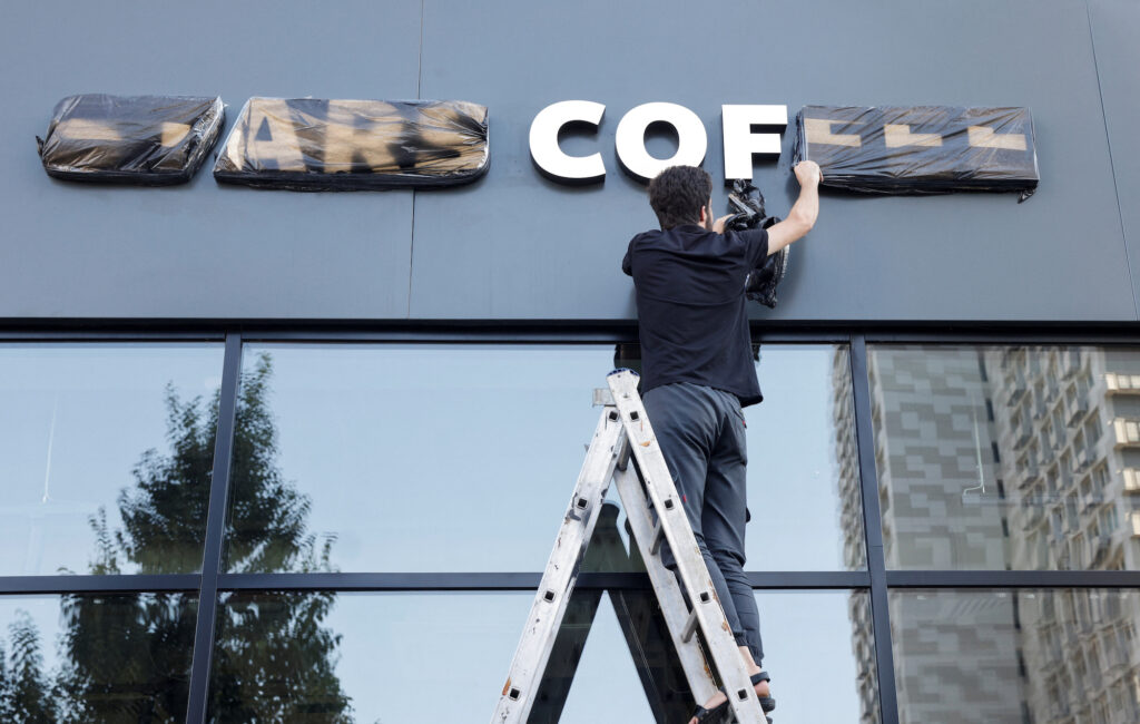 A staff removes the cover from a sign of the new coffee shop Stars Coffee, which opens following Starbucks Corp's exit from the Russian market, in Moscow, Russia
