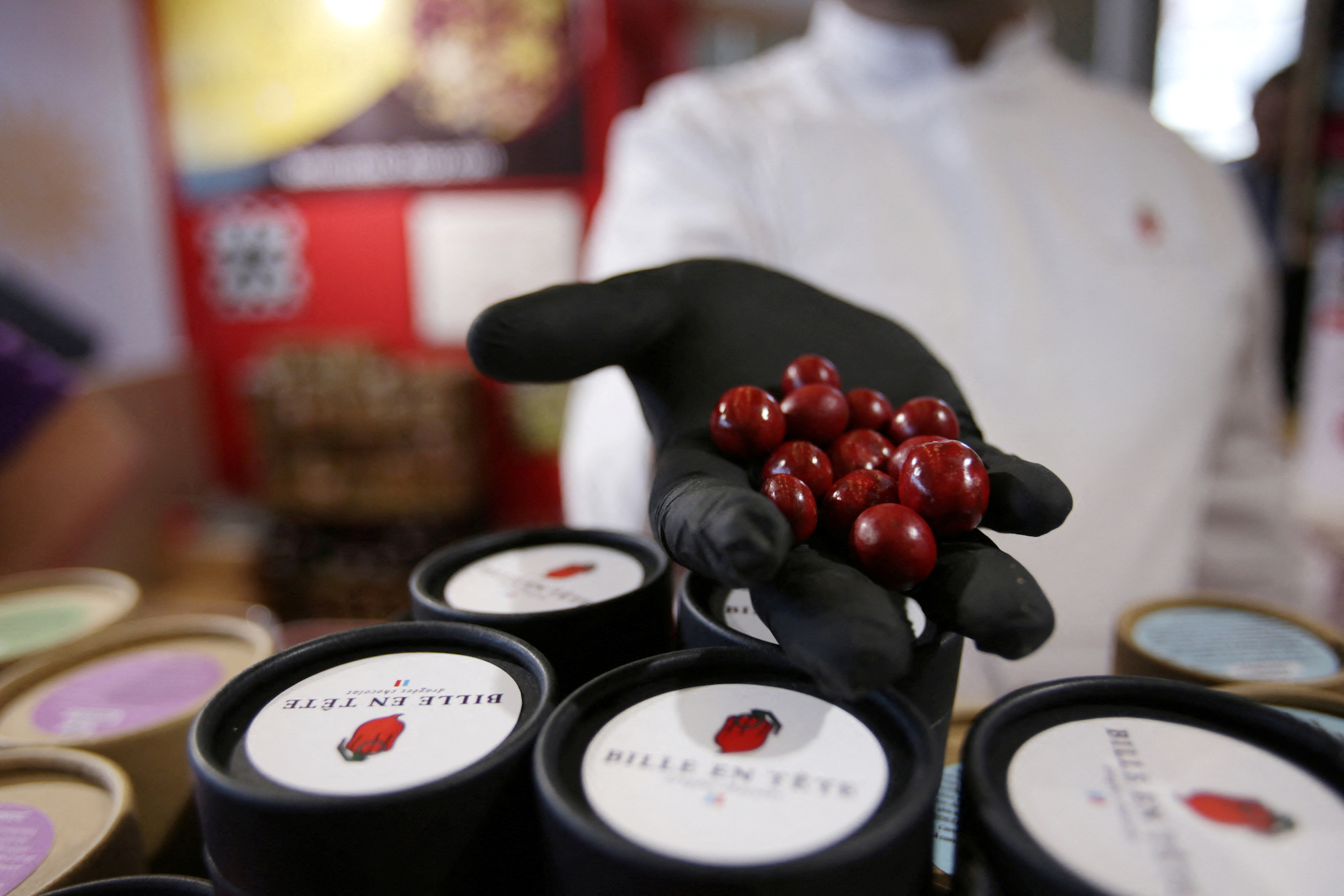 French chocolatier Damien Vidal poses with chocolates flavored with Carolina Reaper chilli pepper at the Paris Chocolate fair in Paris, France
