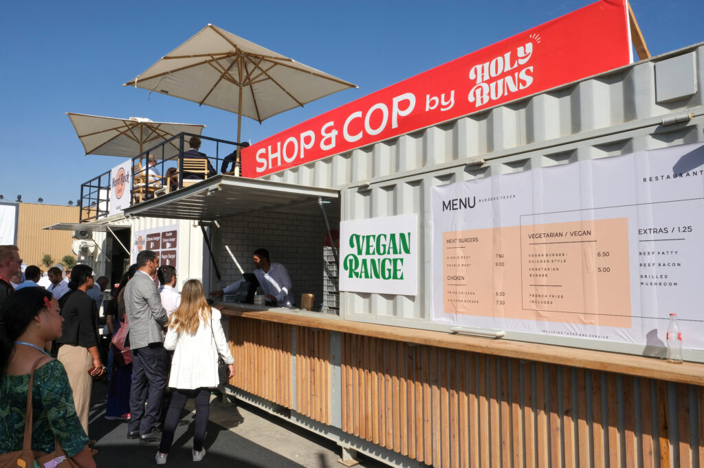 People queue at food stands with vegan options at the COP27 climate summit in Red Sea resort at Sharm el-Sheikh, Egypt