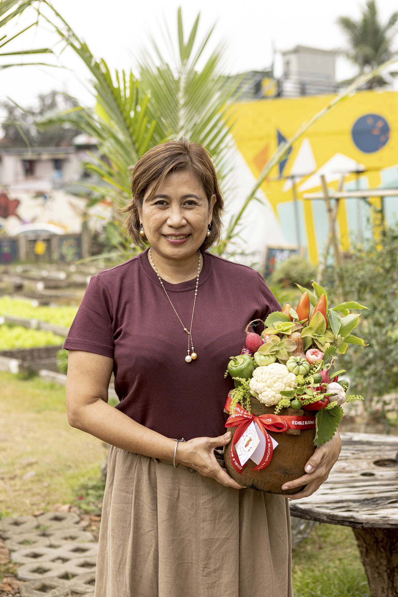 Louie's wife Maye Araneta-Gutierrez with a vegetable bouquet she makes and arranges herself. Her "edible blooms" are also available for sale at the farm