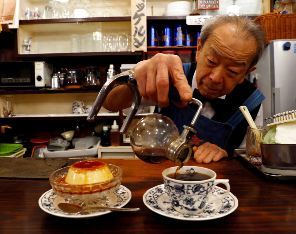 Shizuo Mori serves a pudding and a cup of coffee during a photo opportunity at his Heckeln coffee shop in Tokyo, Japan