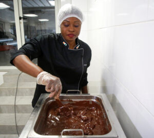 Viviane Kouame, Ivorian chocolate artisan who aims to promote country's origin, mixes chocolate paste during the production of chocolates at Chocovi, her chocolate factory in Abidjan, Ivory Coast