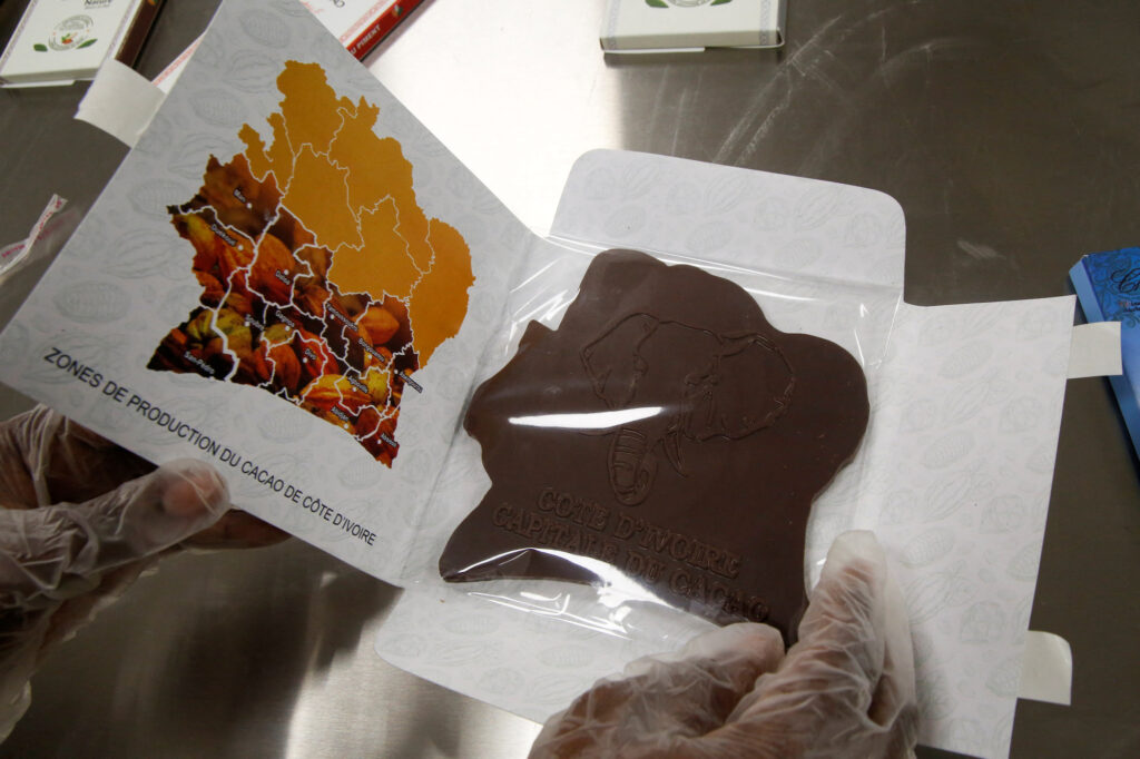 An employee prepares to pack a chocolate bar in the shape of Ivory Coast map at Chocovi, the chocolate factory of Viviane Kouame