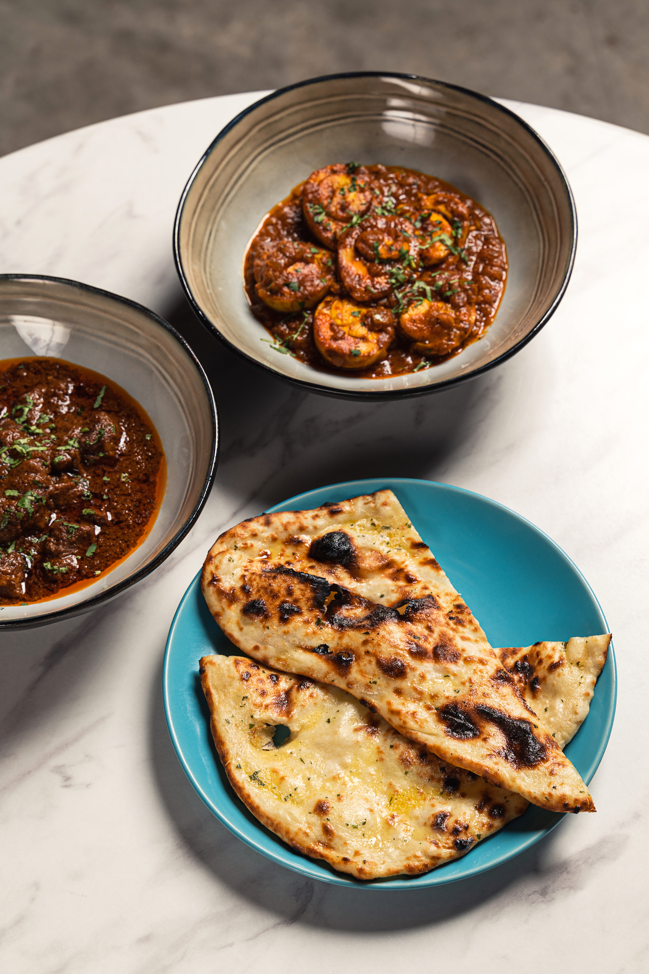 Dhaba-style egg curry, butter naan, and rogan gosht