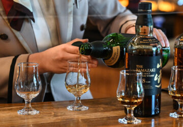 This photo taken on March 27, 2023 shows an employee pouring samples of whisky at the Suntory Yamazaki Distillery where the company's whisky is produced, in the town of Yamazaki, between Kyoto and Osaka. Japan's Yamazaki distillery marks its 100th anniversary this year with plenty to celebrate, as the country's acclaimed aged whiskys command increasingly eye-watering prices thanks to growing demand and longstanding shortages. (Photo by Richard A. Brooks / AFP) / TO GO WITH Japan-beverage-whisky-suntory, FOCUS by Natsuko FUKUE