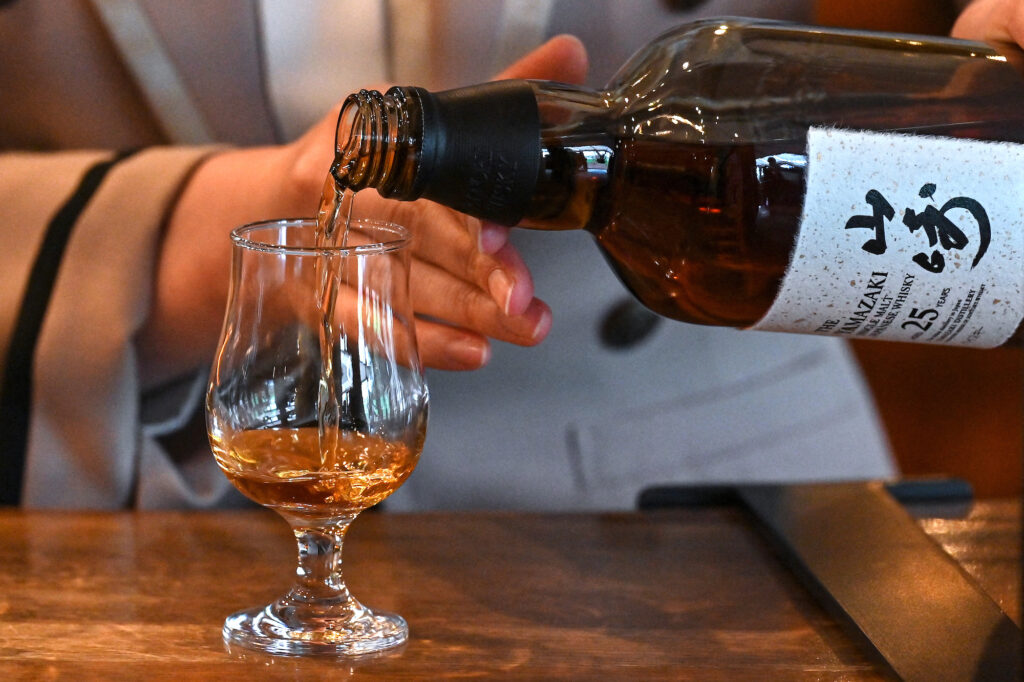 An employee pouring samples of whisky at the Suntory Yamazaki Distillery