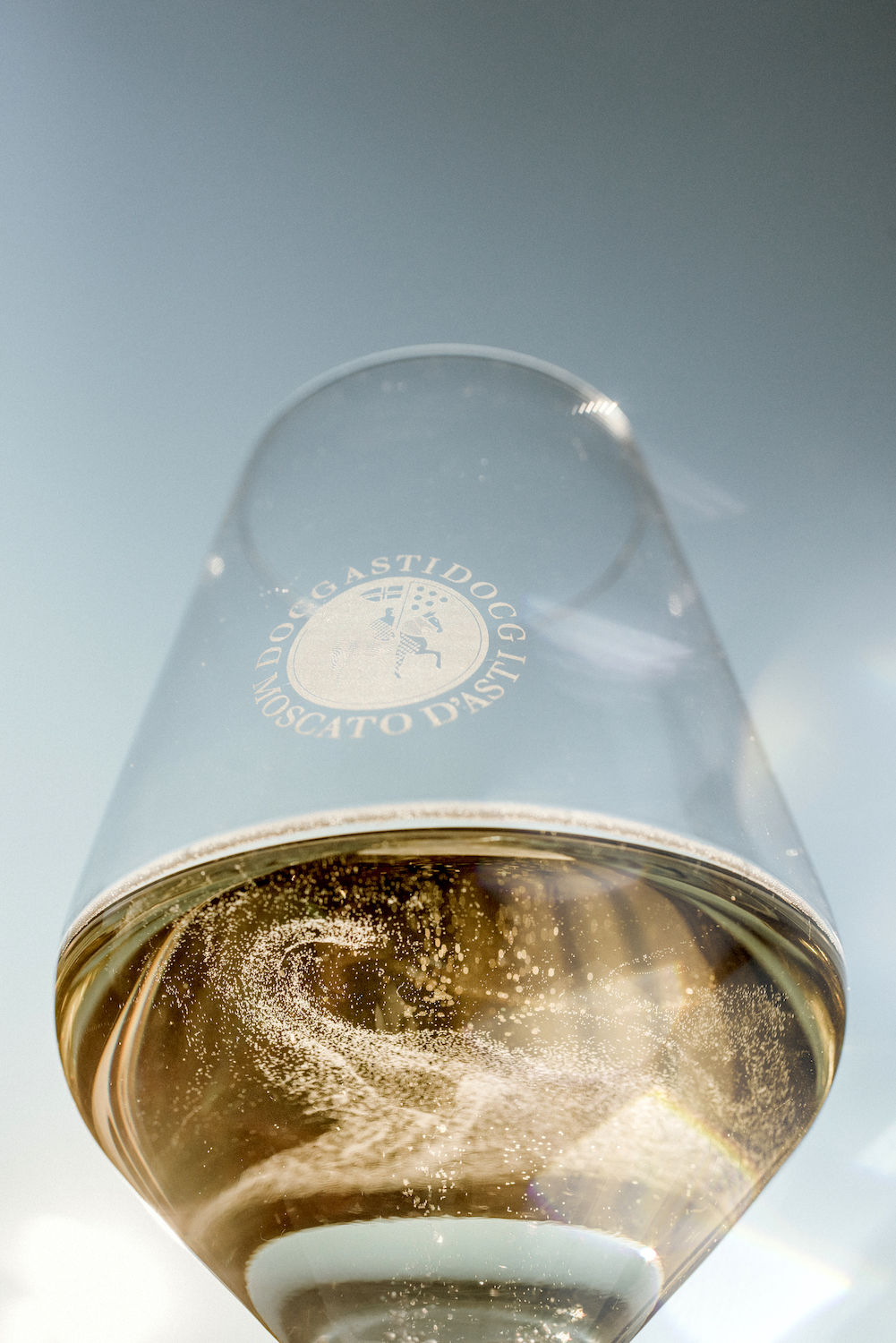 A glass of the Moscato d’Asti glistening like gold under the Italian sun