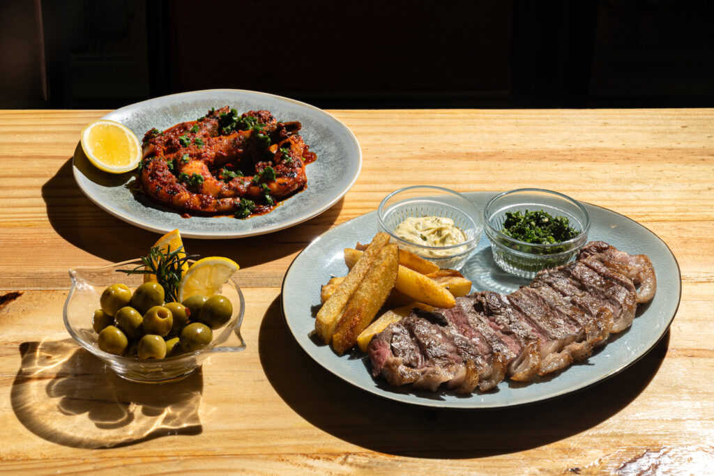Marinated olives, 30-day aged steak, and shrimps in nduja butter and gremolata