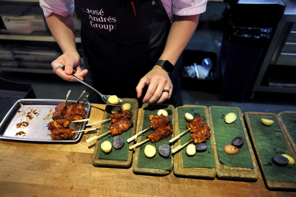 Chef Daniel Lugo plates lab-grown chicken from Good Meat that he grilled at Jose Andres's China Chilcano, in Washington