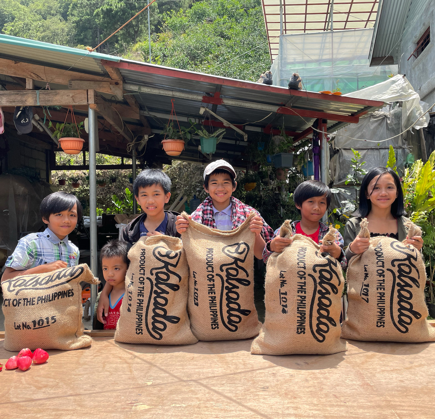 The children of the coffee farming community in Sitio Belis, holding up sacks of Kalsada beans