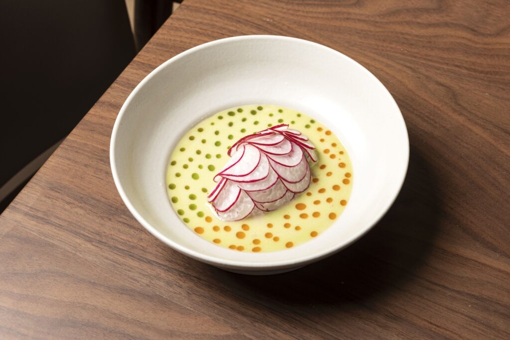 Fit for fine dining, this mound of shrimp tartar covered in an armor of radish slices protected by a moat of cucumber soup