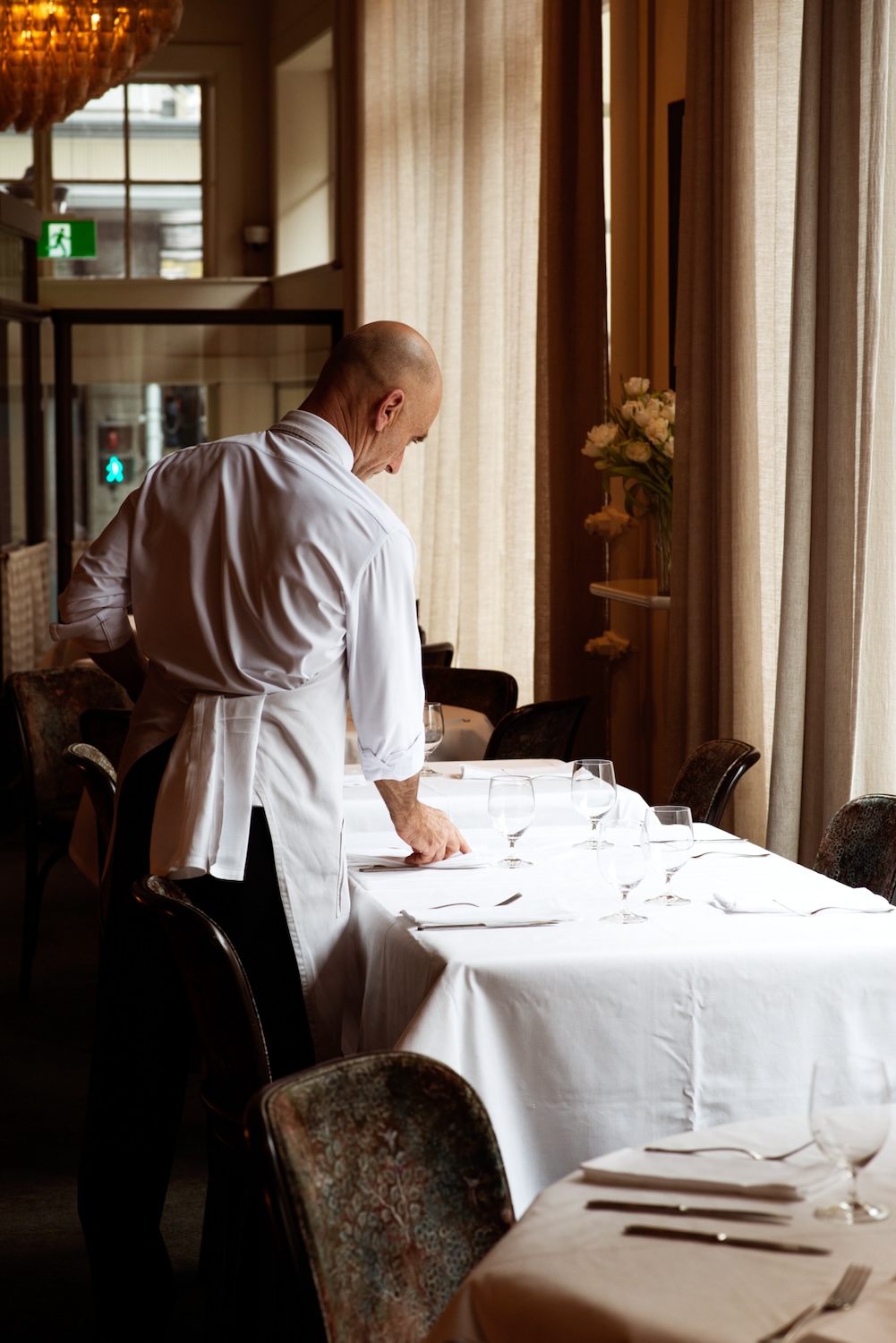 A waiter setting the tables before the start of service