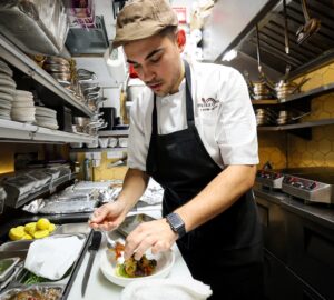 Chef Davide Sanna works in the kitchen of Piccola Cucina in the SoHo area of New York City, U.S., November 22, 2023. REUTERS/Brendan McDermid