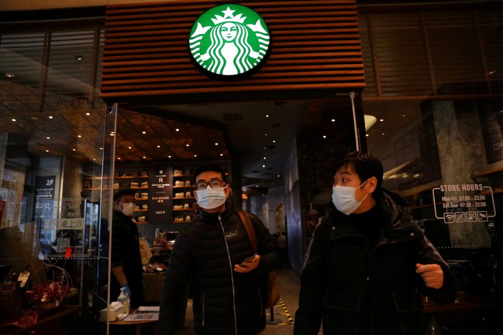 FILE PHOTO: People leave a Starbucks flagship store in Beijing, China January 18, 2022. REUTERS/Tingshu Wang/File Photo