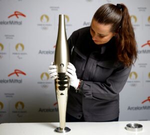 FILE PHOTO: Employee Camille Eudeline holds a torch for the Paris 2024 Olympic and Paralympic Games, manufactured by ArcelorMittal, world leader in steel and Official Partner of the Games, during a press visit at the Guy Degrenne factory in Vire, France, November 17, 2023. REUTERS/Stephane Mahe/File Photo