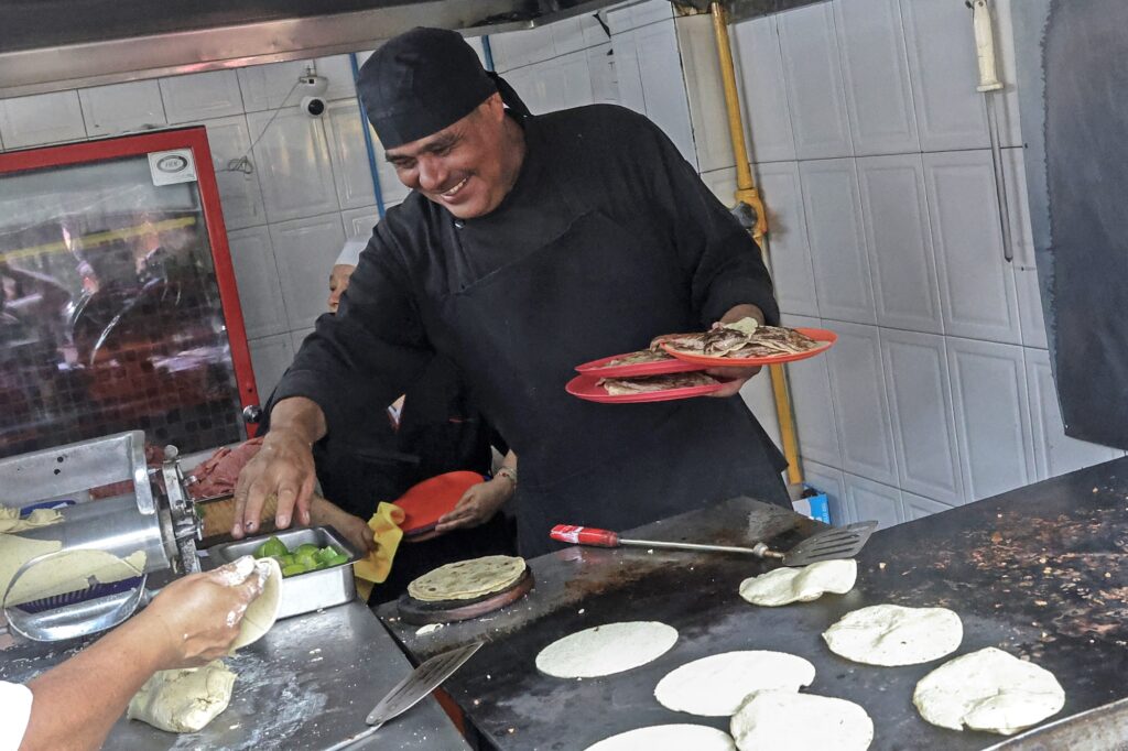 Chef Arturo Rivera Martinez prepares tacos at Taqueria El Califa de Leon restaurant in Mexico City on May 15, 2024. A hole-in-the-wall taqueria is among the first restaurants in Mexico to be awarded a star by the prestigious Michelin Guide -- an accomplishment its owner credits to "love and effort". (Photo by Silvana FLORES / AFP)